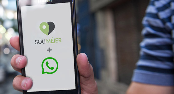 celular com o logo do WhatsApp e do Sou Méier na tela