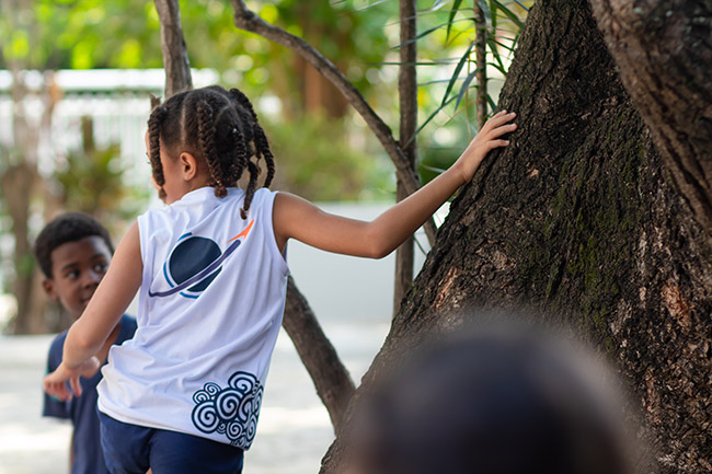 Aluna do colégio Mundo Up no Méier ao lado de uma árvore