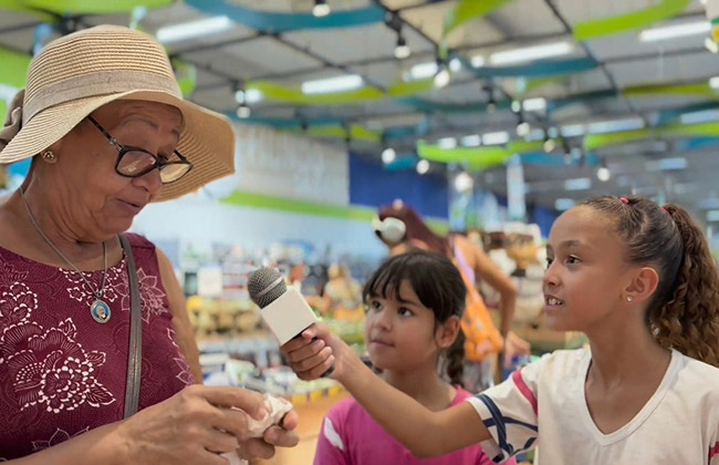 Alunas do Mundo Up entrevistando uma senhora no supermercado no Méier.